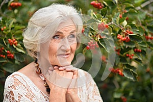 Portrait of happy senior woman posing at forest