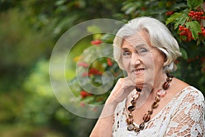 Portrait of happy senior woman posing at forest