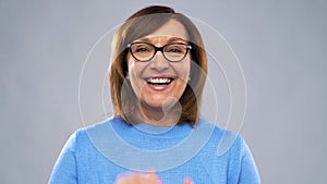 Portrait of happy senior woman putting glasses on