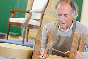 Portrait happy senior worker sitting in workshop