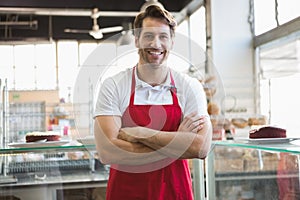 Portrait of happy server with arms crossed