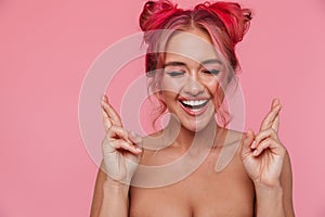 Portrait of happy shirtless young woman keeping fingers crossed