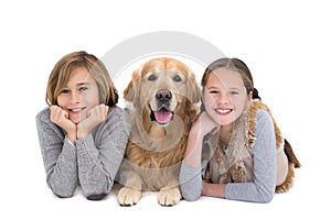 Portrait of happy siblings lying on the floor with their dog