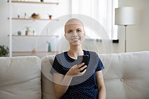 Portrait of happy sick woman suffer from cancer use smartphone