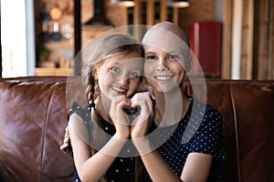 Portrait of happy sick young mom hug with little daughter