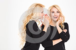 Portrait of a happy sisters twins gossiping