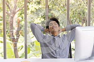 Portrait of happy smart young asian businessman smile  and emotion glad and rest room with desktop computer in office working room