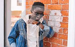 Portrait happy smiling african man with smart watch using voice command recorder or takes calling on a city street