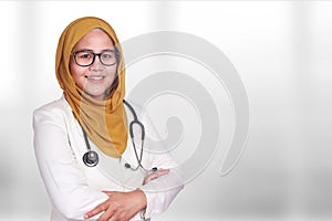 Portrait of happy smiling Asian muslim woman wearing hijab and suite. Confidence female doctor with crossed arms, healthcare and