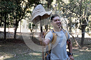 Portrait of a happy smiling Asian tourist, 30-35 years old, backpacking in a national park. asian male tourist enjoying