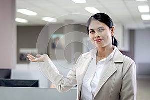 Portrait happy smiling Asian woman officer worker standing, pretending to hold something or welcoming to her office, confident