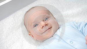 Portrait of happy smiling baby boy with blue eyes smiling on dressing table. Concept of hygiene, baby care and