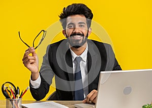 Portrait of happy smiling bearded indian business man at home office look away turn head at camera