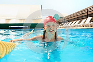 The portrait of happy smiling beautiful teen girl at the pool