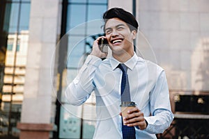 Portrait of a Happy Smiling Businessman Talking on Mobile Phone in the Urban City. Lifestyle of Modern People