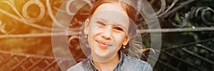 Portrait happy smiling candid eight year old kid girl face sits on bench in nature. prepubertal age of children and lives, mind ps