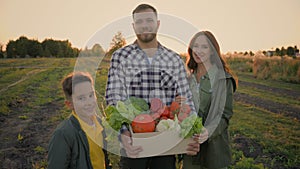 Portrait happy smiling Caucasian family mother son kid boy father holding hands box different fresh vegetables outside