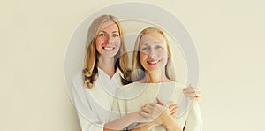 Portrait of happy smiling caucasian middle aged mother or sister and adult daughter together