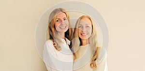 Portrait of happy smiling caucasian middle aged mother or sister and adult daughter together