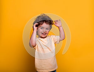 Portrait of a happy smiling child boy. Back to school or kindergarten. Funny kid with raised hands up.