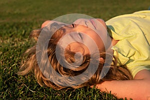 Portrait of a happy smiling child boy on grass field. Kids dreaming. Summer dream. Kid dreams on grass. Childhood dream