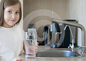 Portrait of happy smiling child with glass of fresh water. Consumption of tap water contributes to the saving of water in plastic