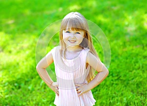 Portrait of happy smiling child little girl on the grass