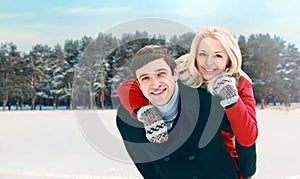 Portrait happy smiling couple having fun at winter day, man giving piggyback ride to woman