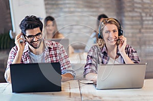 Portrait of happy smiling customer support phone operator at workplace.