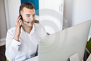 Portrait of happy smiling customer support phone operator at workplace. Call center