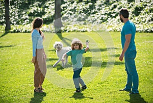 Portrait of a happy smiling family with dog relaxing in park.