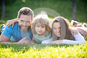 Portrait of a happy smiling family hugging in park. Family and child outdoors in summer nature.