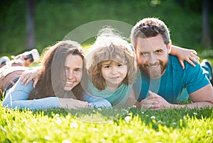 Portrait of a happy smiling family hugging in park. Family and child outdoors in summer nature.