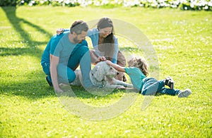 Portrait of a happy smiling family with pet dog relaxing in park.