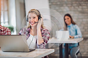 Portrait of happy smiling female customer support phone operator