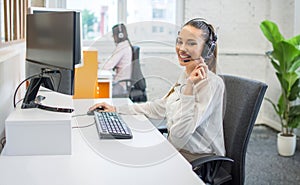 Portrait of happy smiling female customer support phone operator at workplace.