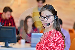 Portrait of happy smiling female customer support phone operator at workplace.