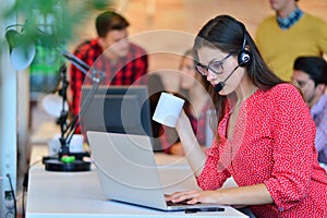 Portrait of happy smiling female customer support phone operator at workplace.