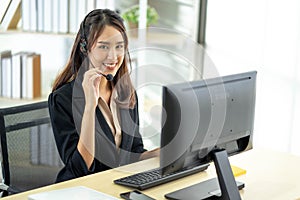 Portrait of happy smiling female customer support phone operator at workplace. Professional operator concept