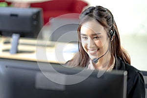 Portrait of happy smiling female customer support phone operator at workplace. Professional operator concept