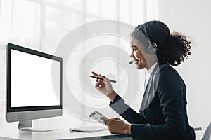 Portrait of happy smiling female customer support phone operator at workplace. Smiling beautiful African American woman