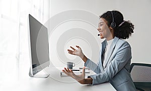 Portrait of happy smiling female customer support phone operator at workplace. Smiling beautiful African American woman