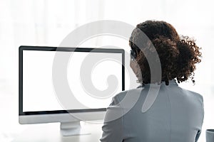 Portrait of happy smiling female customer support phone operator at workplace. Smiling beautiful African American woman