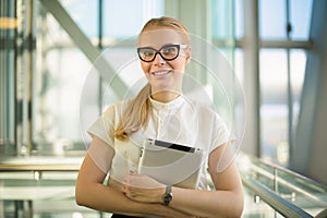 Portrait of a happy smiling female intelligent business worker in office wear and glasses