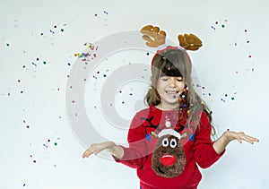 Portrait of happy smiling kid in a red knitted pullover with a Santa hat on head isolated on white background.