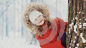 Portrait of happy smiling little girl child in winter over a snowy background