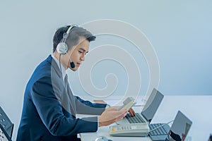 Portrait of happy smiling male customer support phone operator at workplace