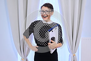 Portrait of happy smiling mature business woman in glasses with papers