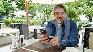 Portrait of happy smiling mid adult man with phone