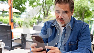 Portrait of happy smiling mid adult man with phone